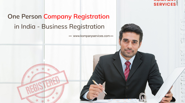 A professional man in a suit sits at a desk with documents, using a tablet. The text reads "One Person Company Registration in India - Business Registration" with a "REGISTERED" stamp. Branding for Kompany Services is visible in the top right corner and on the left side.