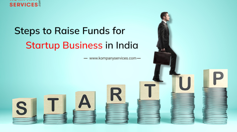 A man in a suit carrying a briefcase steps upward on wooden blocks spelling "STARTUP," placed on stacks of coins. The text reads "Steps to Raise Funds for Startup Business in India" with the website "www.kompanyservices.com" mentioned.