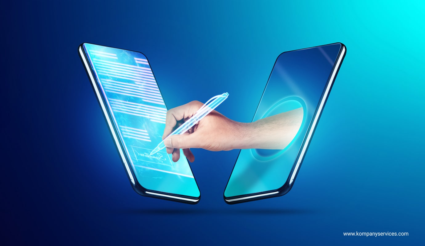 A digital illustration shows two smartphones facing each other against a blue background. A hand extends from one phone, holding a pen, and signs a document displayed on the screen of the other phone. The image represents Digital Signature Certificates or document signing.