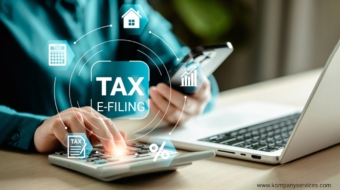 Person using a smartphone and calculator with a laptop on a desk, surrounded by tax-related icons, including a house, a graph, a percentage symbol, and documents. Overlaid text reads "Income Tax E-Filing." Website "www.kompanyservices.com" displayed in the corner.